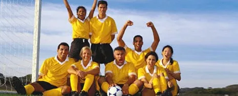 A football team celebrating together on the pitch